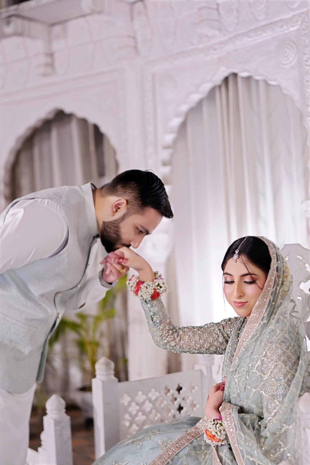 Groom gently kissing the bride's hand at their wedding venue